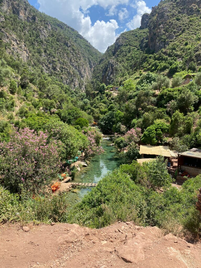 Scenic view of a lush green valley with a river running through, surrounded by mountains.