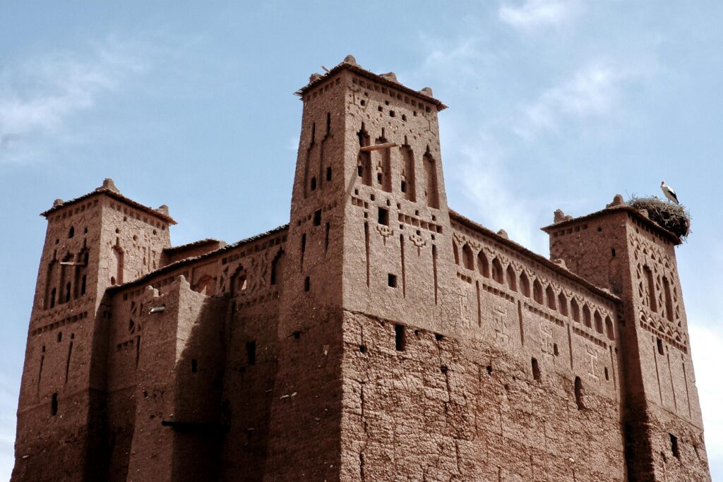 Captivating view of a traditional Kasbah in Ouarzazate, Morocco under a clear blue sky.