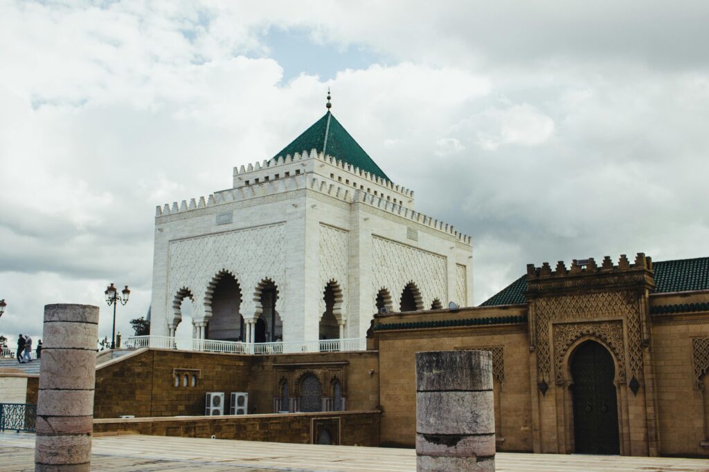 Explore the historic Hassan Tower in Rabat, showcasing intricate Islamic architecture beneath a dramatic sky.